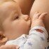 A caucasian newborn baby boy breastfeeding .